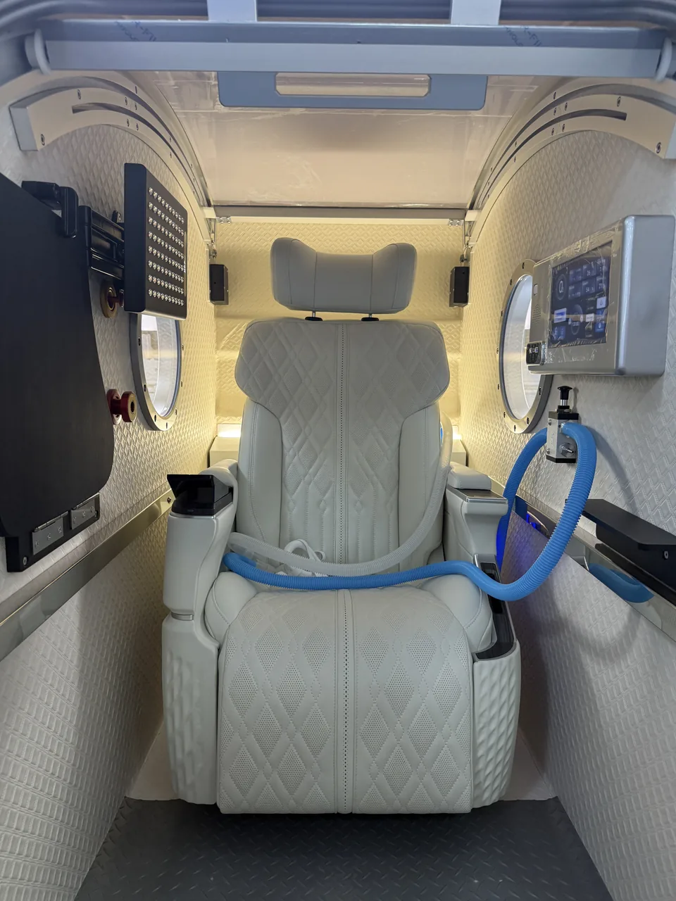 Grey seat, folding table and infrared panel inside ORION